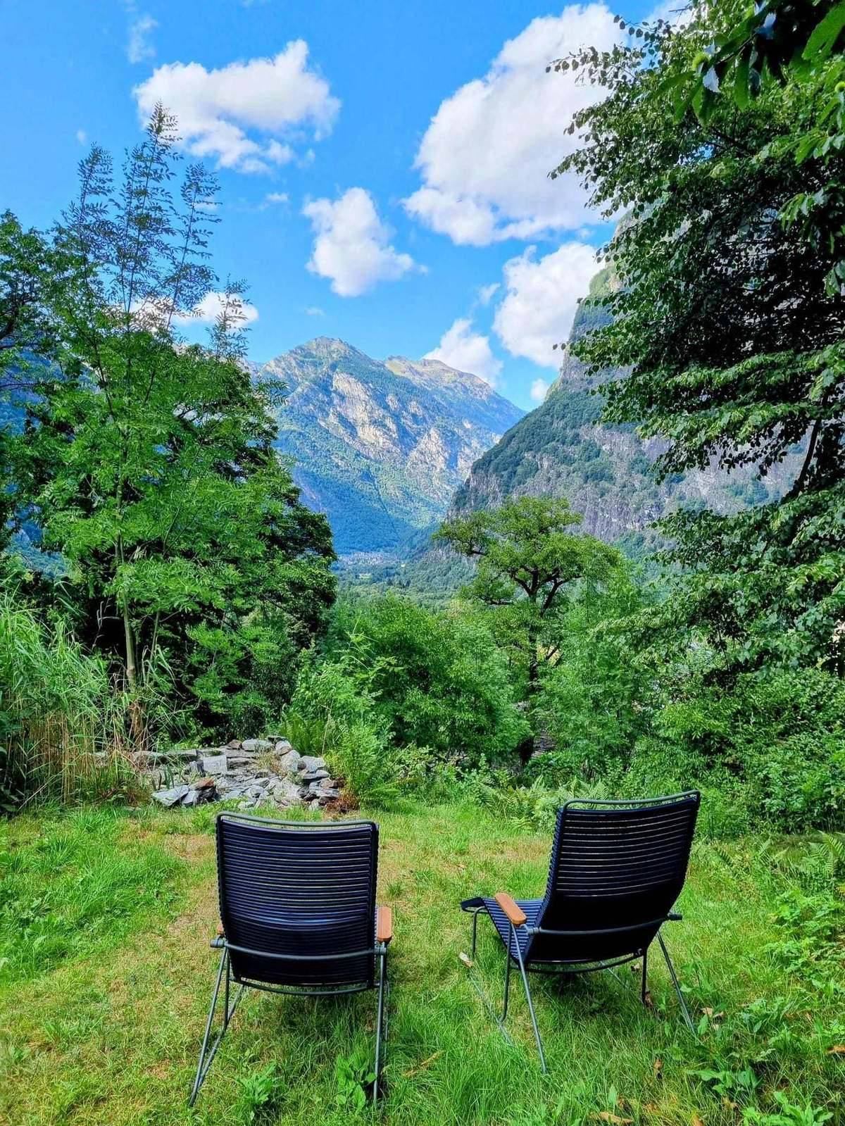 Blick über die Wiese auf Casa Isolina im Bergwald