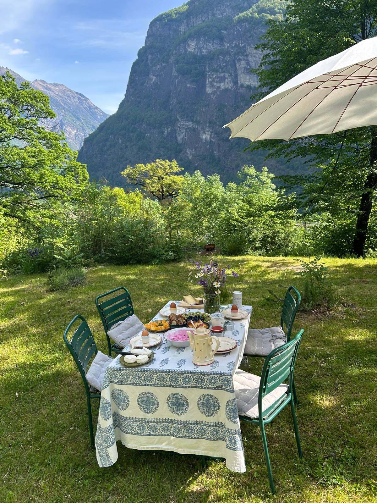 Frühstückstisch im Garten mit Blick auf die Felskulisse