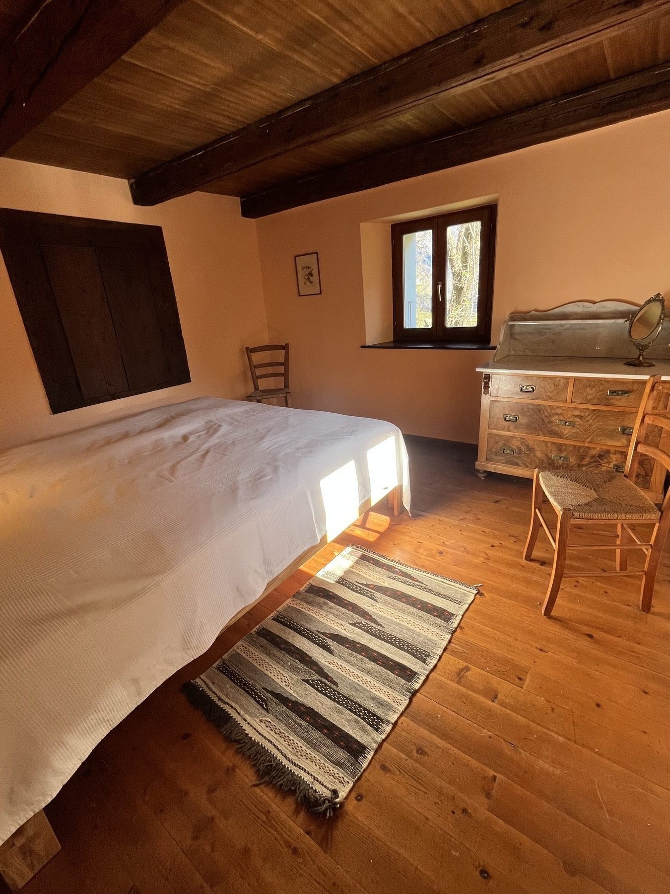 Hauptschlafzimmer mit Doppelbett und Holzbalken